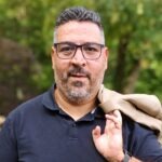 Sebastian Korbmann, Gründer von Elixior, Porträt vor grünem Hintergrund